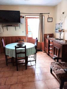 a dining room with a table and chairs and a television at Maison charmante à Ombrée d'Anjou avec jardin et terrasse in Bourg-lʼÉvêque