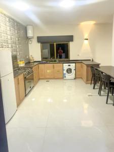 杰拉什Olive Tree Farm & Chalet的一间大厨房,配有桌子,铺有白色的地板