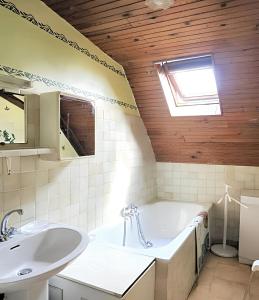 a bathroom with a bath tub and a sink at Maison charmante à Ombrée d'Anjou avec jardin et terrasse in Bourg-lʼÉvêque