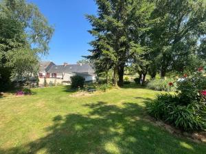 a yard with green grass and trees and a house at Maison charmante à Ombrée d'Anjou avec jardin et terrasse in Bourg-lʼÉvêque +13 photos