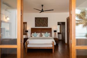 a bedroom with a bed and a ceiling fan at Kixi Beach in Unawatuna +87 photos