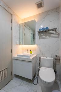 a bathroom with a toilet and a sink and a mirror at Roomio Paris Hoang Kim-Shared Apartment in Ho Chi Minh City