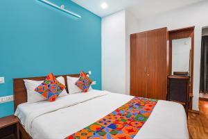 um quarto com uma grande cama branca com almofadas coloridas em Via RLV Green Palace - Nr Kengeri Satellite Town em Bangalore