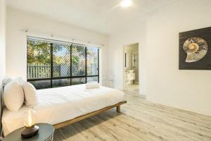 バイロンベイにあるBeachfront Beach Break 1 - Byron Bay Holiday Apartment with Pool, 3 Bedrooms, Beach Access & Parkingのベッドと大きな窓のある寝室