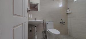 a white bathroom with a toilet and a sink at The Cosy Cottage in Coonoor +13 photos