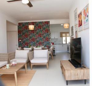 a living room with a couch and a tv at Luxueux Appartement 3 chambres in Flic-en-Flac