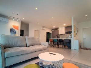 a living room with a couch and a table at Jk DeLOFTS 12Pax New Low-Density Scenic View Apartment in Kuching