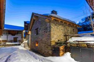 ein Steinhaus im Schnee in der Unterkunft B&B LA VILLE CHAMOIS in Chamois