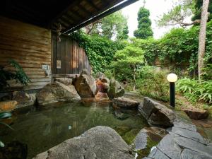 a pond in a yard with rocks and a house at 緑風苑 きよはる Ryokufuen Kiyoharu in Takayama