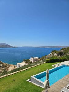 a villa with a swimming pool and a view of the ocean at Villa Ektoras in Plaka