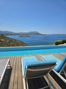 a swimming pool with a lounge chair on a deck at Villa Ektoras in Plaka