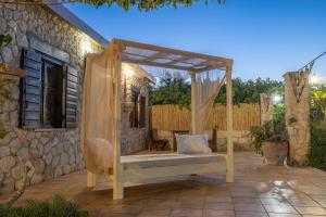 un lit d'extérieur avec un auvent sur une terrasse dans l'établissement Vardiola Houses, close to Agios Sostis Beach, by ZanteWize, à Lithakia