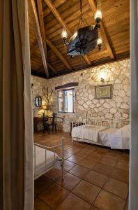 une chambre avec deux lits et un mur en pierre dans l'établissement Vardiola Houses, close to Agios Sostis Beach, by ZanteWize, à Lithakia 89 autres photos