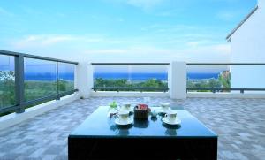 a table on a balcony with a view of the ocean at Coastline Azure B&B, 民宿編號0911 in Donghe