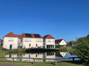 a house with solar panels on its roof next to a lake at Krug zum Schlaubetal in Mixdorf