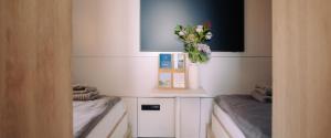 a room with two beds and a vase of flowers at Spreeapartment MARA in Berlin