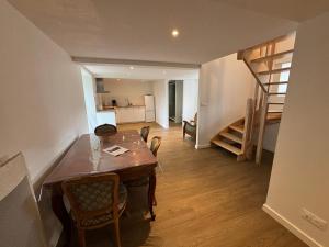 a kitchen and dining room with a table and a staircase at Gites du Manoir de Kergoniou Saint Joseph in Paimpol +12 photos