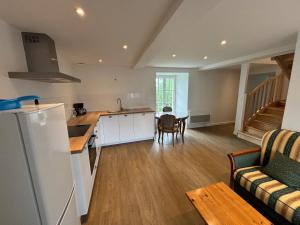 a kitchen and living room with a table and a refrigerator at Gites du Manoir de Kergoniou Saint Joseph in Paimpol