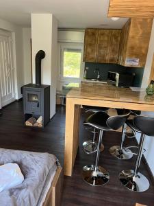 a kitchen with a stove and a counter with bar stools at Légy Ott Kuckó in Zalaszentlászló +7 photos