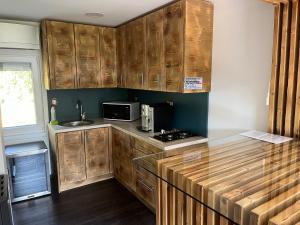 a kitchen with wooden cabinets and a counter top at Légy Ott Kuckó in Zalaszentlászló