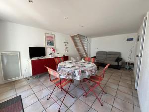 a dining room with a table and chairs and a couch at L'Océanide in Saint-Gilles-Croix-de-Vie