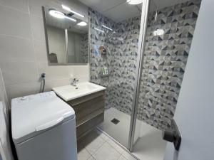 a bathroom with a sink and a shower at L'Océanide in Saint-Gilles-Croix-de-Vie