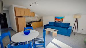 a living room with a blue couch and a table at Apartmani Radovic in Bijela