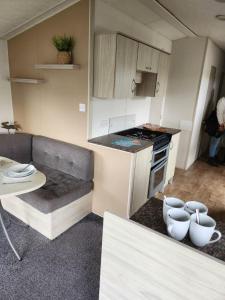 a small kitchen with a couch and a table at 20 Cherry Tree Walk Lyons Robin Hood in in Rhyl +10 photos