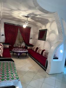 una sala de estar con un sofá y una mesa en Martil Bel appartement lumineux, situé à seulement 15 minutes à pied et 5 minutes en voiture de la plage, idéal pour les vacances en famille ou entre amis, en Martil