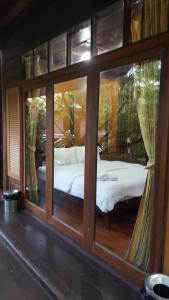 เตียงในห้องที่ เรือนไม้ชายคลอง
