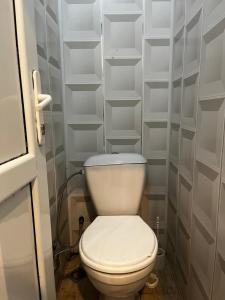 Un inodoro blanco en un baño con estantes blancos. en House in the Riverside, en İsmayıllı