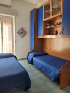 two beds in a room with blue walls at Casa MAIO, attico molto panoramico, in centro storico in Taormina