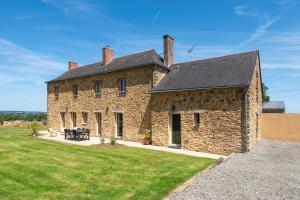 an old stone house with a picnic table in the yard at La Villa au Grand Chêne - Charmante maison pour 10p in Challain-la-Potherie