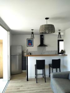 een keuken met een aanrecht, 2 stoelen en een koelkast bij T2 MARINE Le LAVANDOU in Le Lavandou