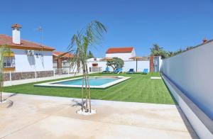 a backyard with a swimming pool and a palm tree at Alojamiento Rural Las Quintas in Conil de la Frontera