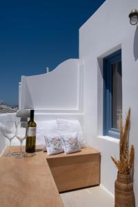 a table with a bottle of wine and two glasses at Sunny house Mykonos town kohili in Megali Ammos