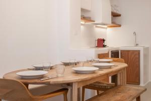a wooden table with bowls and plates on it in a kitchen at Sunny house Mykonos town kohili in Megali Ammos +15 photos