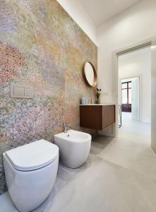 ein Badezimmer mit weißer Toilette und Waschbecken in der Unterkunft Matteotti Royale Apartments in Syrakus + 88 Fotos