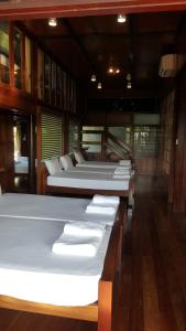 a room with several beds on a boat at Ruean Mai Chai Khlong in Amphawa