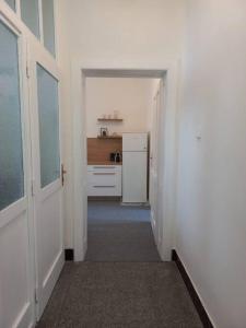 a hallway leading to a kitchen with a refrigerator at LP 1926 aneb U nás doma in Zlín