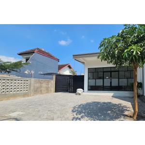 a house with a tree in front of a driveway at Guest House Saqeena Syariah Near Blitar Park RedPartner in Blitar