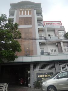 ein Gebäude mit einem davor geparkt in der Unterkunft Phuc Hung 2 Hotel in Rạch Giá