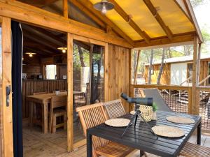 a screened in porch with a table and chairs at Camping la Tamarissière in Agde