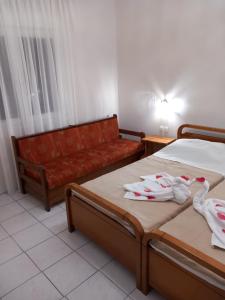 a hotel room with two beds and a couch at Coastal Dream Apartments in Keramoti
