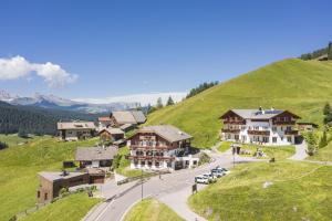 a resort on top of a hill with cars parked at Hotel Daniel Apartments in Selva
