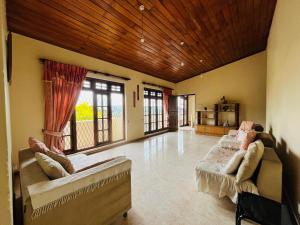 a large living room with two beds and windows at Mountain Breeze Uplands in Kandy