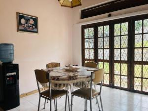 a dining room with a table and chairs and windows at Mountain Breeze Uplands in Kandy
