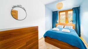 a bedroom with a bed and a mirror at VacationClub - Leśny Dom 18 Apartament 15 in Karpacz +5 photos