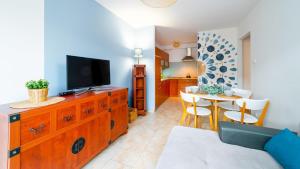 a living room with a television on a wooden dresser at VacationClub - Leśny Dom 18 Apartament 15 in Karpacz
