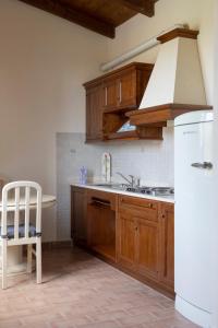 a kitchen with wooden cabinets and a white refrigerator at Fattoria Il Giardo in Pietrasanta